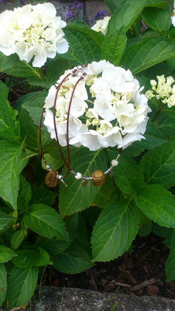 Fußkettchen Essigbaumholz vor Hortensie