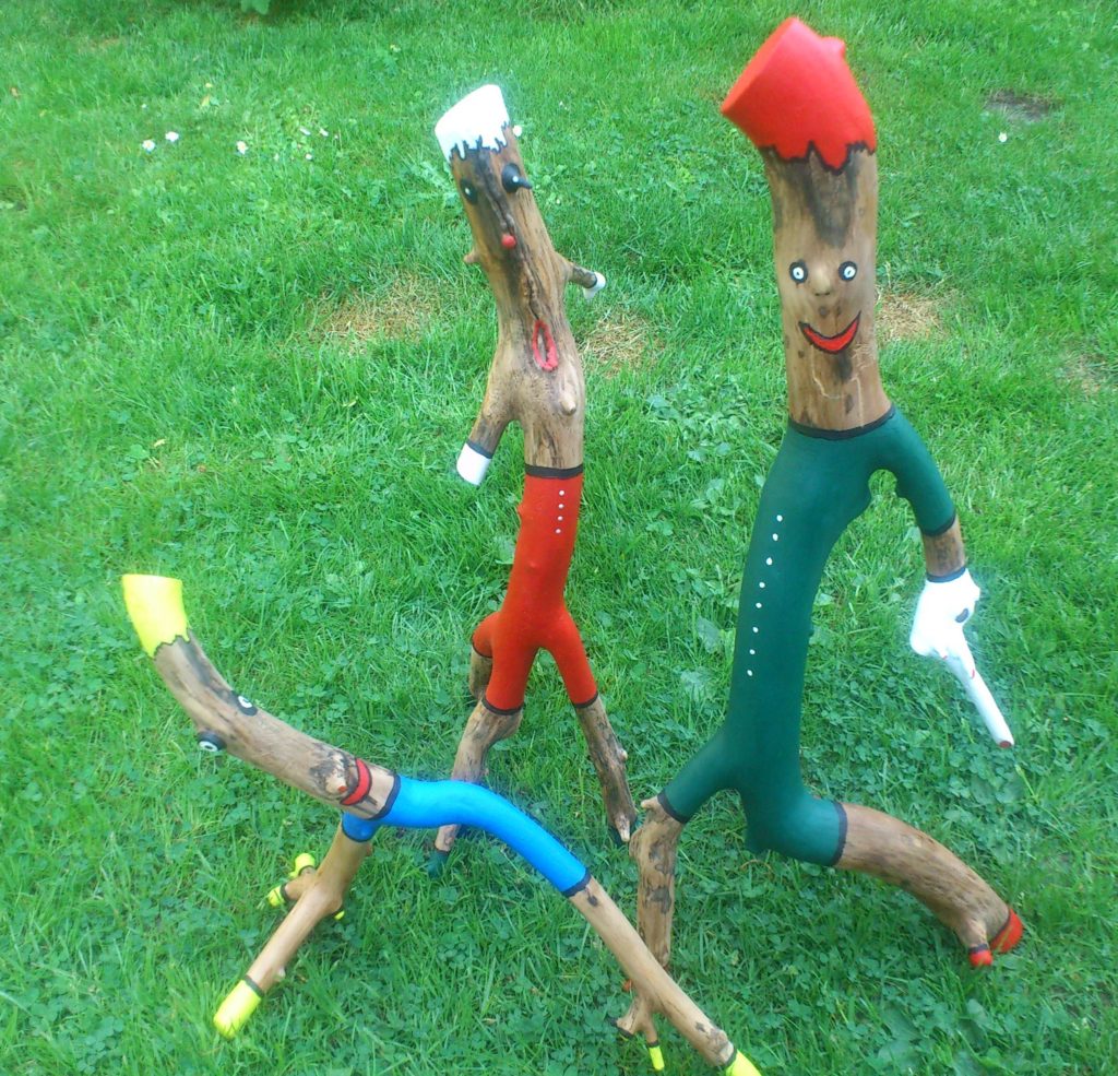 Holzfiguren: Der Mahner, der Sprinter und die Diva. Jede Figur ist ca. 50 cm hoch und mit Acrylfarben bemalt.
