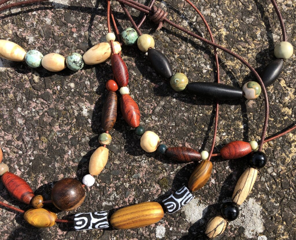 Halsketten aus handgearbeiteten Holzelementen und Schmucksteinen